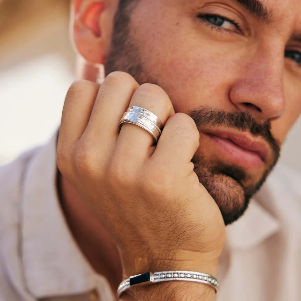 Man wears Karma Abundance spinner ring